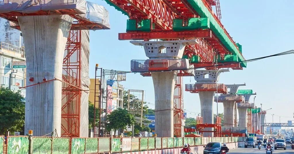 Construction cranes on a bridge in Thailand, highlighting ongoing infrastructure development efforts in the region.