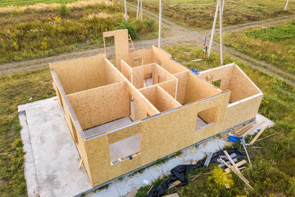 Aerial view of a partially constructed modular house with wooden particle board walls, showing the rise of Modular Construction Thailand.