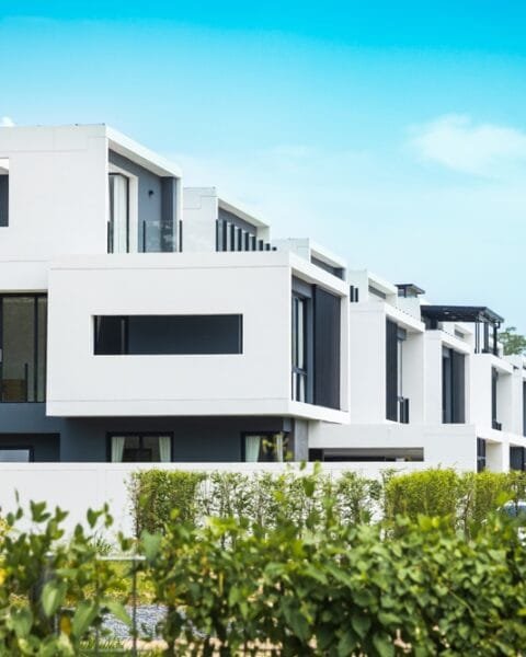 Phuket's modern white duplex townhouses with balconies in a row under blue sky, symbolising Thailand Real Estate Trends.