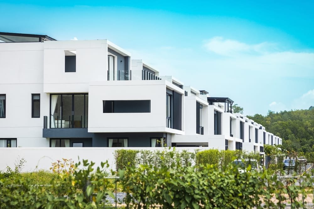 Phuket's modern white duplex townhouses with balconies in a row under blue sky, symbolising Thailand Real Estate Trends.