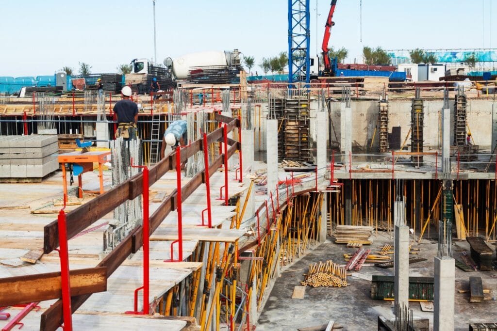 Construction Project Delays in Thailand: A construction site with workers, concrete structures, and heavy machinery.